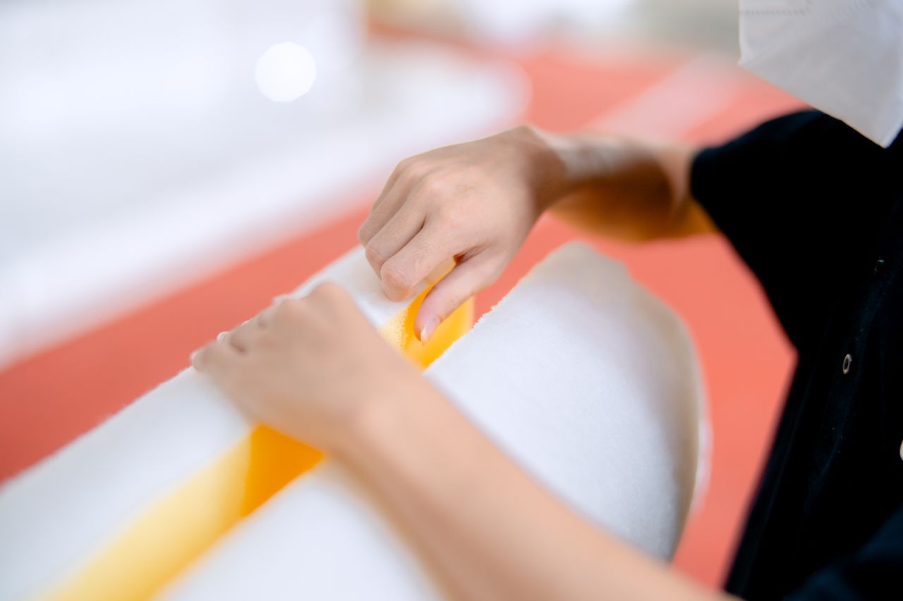 Mastering the First Impression: Your intriguing post title goes here Close-up of a person manipulating polyurethane foam, showcasing detailed handwork in an industrial setting.